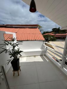 une plante en pot posée sur un balcon couvert dans l'établissement Gute Morro Villa Apartments, à Cairu