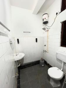 a bathroom with a toilet and a sink at Varnas Cosy Stay in Guwahati