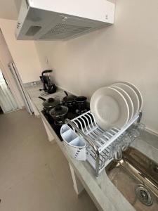 une cuisine avec une cuisinière avec des assiettes et des casseroles dans l'établissement Gute Morro Villa Apartments, à Cairu