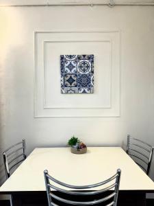 a white table with chairs and a picture on the wall at Varnas Cosy Stay in Guwahati