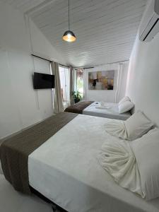 - une chambre avec 2 lits et une télévision dans l'établissement Gute Morro Villa Apartments, à Cairu