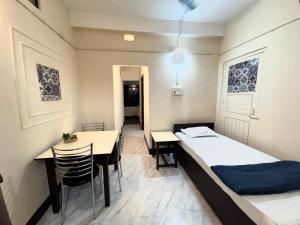 a small room with a bed and a dining table at Varnas Cosy Stay in Guwahati