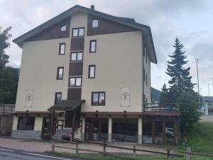 a large white building with a gambrel at Hotel Genevris Cinq in Sauze dʼOulx