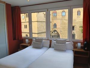 a bed in a room with a large window at Ekia Pentsioa in Zarautz