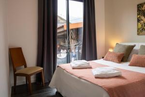 a bedroom with a bed with a window and a chair at Cottage Bela Vista by Escape to Madeira in Cedros