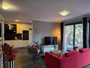 a living room with two red couches and a tv at Cottage Bela Vista by Escape to Madeira in Cedros