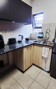 a kitchen with a sink and a counter top at Felinga Guest House in Centurion