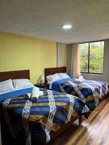 zwei Betten nebeneinander in einem Zimmer in der Unterkunft Jacquelins house in Baños
