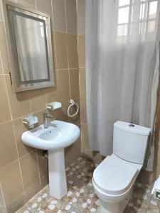 een badkamer met een toilet, een wastafel en een spiegel bij Modern 1 bedroom flats in Tema