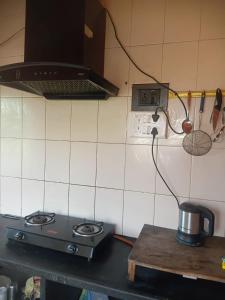 a kitchen with a stove with a clock on the wall at Urban Nest Homestay 3BHK full furnished in Mullāhjor