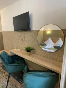 a mirror in a hotel room with a bed at Pensiunea Carina in Bran