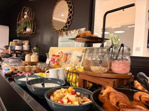 a buffet with bowls of food on a counter at Campanile Annemasse Gare– Genève in Annemasse