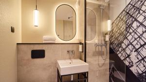 ein Badezimmer mit Waschbecken und Spiegel in der Unterkunft Campanile PRIME - Paris Porte d'Italie in Le Kremlin-Bicêtre + 24 Fotos