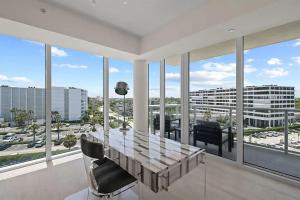 een eetkamer met een tafel en uitzicht op de stad bij Chic Three-Bedroom Oceanfront Apartment with Stunning Views in South Palm Beach +28 foto's