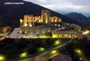 a large building on top of a mountain at night at B&B MALVETUM in Malvito