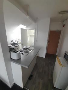 a white kitchen with a counter top and a stove at Canton Principality Stadium Studio Flat in Cardiff
