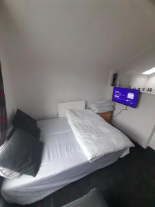 two beds in a small room with a television at Canton Principality Stadium Studio Flat in Cardiff +1 photo