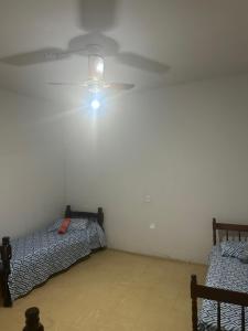 a room with two beds and a ceiling fan at Hotel Automatiza no Centro da Cidade in Uberaba