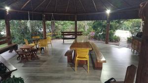 a pavilion with tables and yellow chairs and tables at Passos da Lagoa in Itapemirim +12 photos