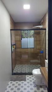 a bathroom with a shower with a toilet and a sink at Passos da Lagoa in Itapemirim