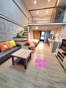 a living room with a couch and a table at Golden Wing樓中樓溫泉宿 in Jiaoxi +9 photos