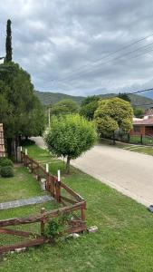 une clôture en bois dans l'herbe à côté d'une route dans l'établissement Lodemarta, à Villa Carlos Paz