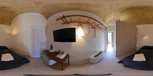een woonkamer met een tv aan de muur bij Il Carrubo residenza Walk&Stay in Matera