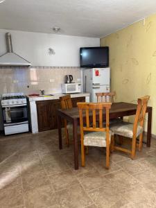 une cuisine avec une table, des chaises et un réfrigérateur dans l'établissement Lodemarta, à Villa Carlos Paz