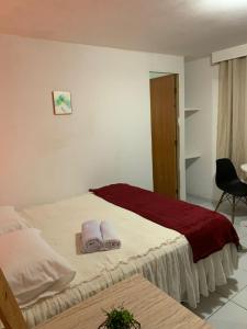 a bedroom with a bed with two towels on it at Pousada e Hostel Ponta de Campina in Cabedelo