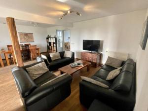 ElsendorpにあるDe open schuurのソファ2つとテレビのあるリビングルーム