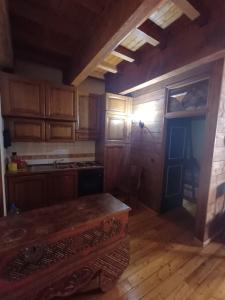 a kitchen with wooden cabinets and a wooden floor at Apartment with fireplace near the Vauban City in Briançon