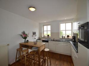 ElsendorpにあるDe open schuurの白いキッチン(木製テーブル、椅子付)