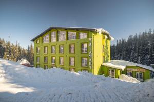 un edificio amarillo con un montón de nieve delante en Diamant Dragobrat, en Dragobrat