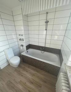 a white bathroom with a tub and a toilet at Apartment O&V 2 in Waldshut-Tiengen