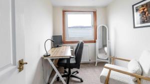 a room with a desk with a computer and a window at Sea The View in Rothesay