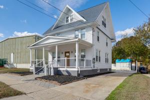 a white house with a porch on a street at 10 Mi to Lincoln Financial Field Family Home! in Colonial Manor