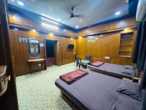 a bedroom with two beds and a desk and a mirror at Perfect Homestay Ujjain in Ujjain