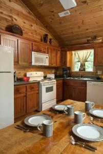 a kitchen with wooden cabinets and a table with plates on it at The Sassafras Breeze in Topton +9 photos