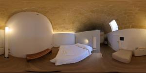 een slaapkamer met een bed in een bakstenen muur bij Il Carrubo residenza Walk&Stay in Matera