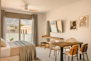 a bedroom with a bed and a desk and a table at Ionian Treasure Suites in EFL