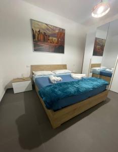 a bedroom with a large bed with a blue blanket at Villa Stella Marina in Porto Cesareo