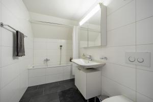 a white bathroom with a sink and a toilet at Swiss Suites - Stusslingen in Lostorf +17 photos