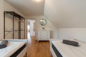 a attic bedroom with two beds and a dresser at Swiss Suites - Stusslingen in Lostorf