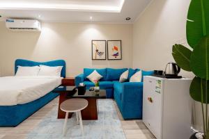 a living room with a blue couch and a refrigerator at استديو رائع في العليا 203 in Riyadh