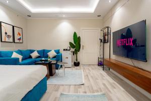 a living room with a blue couch and a tv at استديو رائع في العليا 203 in Riyadh
