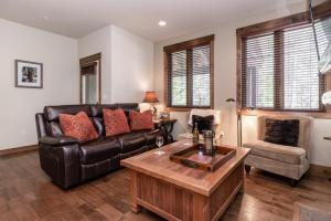 Una sala de estar con un sofá de cuero y una mesa. en Woodwinds 22, en Mammoth Lakes