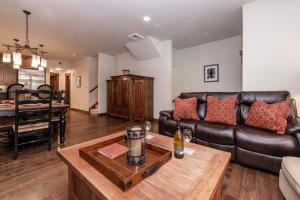 Una sala de estar con un sofá de cuero y una mesa. en Woodwinds 22, en Mammoth Lakes 27 fotos más