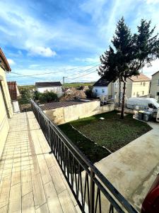 a fence in front of a yard with a tree at Maison cosy in Goussainville +20 photos