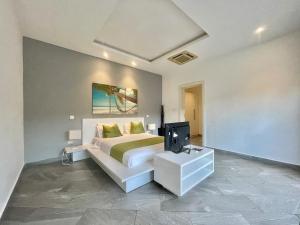ディアニ・ビーチにあるAmber Villas Dianiのベッドとテレビのある寝室 +8枚の写真
