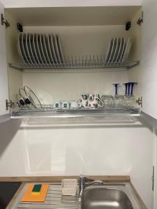 a kitchen with a sink and a shelf with dishes at Villa Stella Marina in Porto Cesareo +57 photos